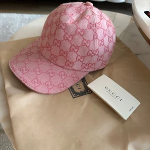 Rosa Gucci keps med GG-mönster - Köpt för 1 år sedan men använder knappt därmed säljer jag den. Säljer den billigt för att jag vill bli av med den, den ligger och dammar i påsen annars. 