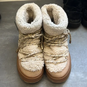Vinter skor - Vinterskor  i beige med fluffigt teddyfoder och grov plattformssula. Snygga snören med svarta detaljer och små nitar på sidan. Perfekta för kalla dagar och har en rund tå. Märke syns tydligt på hälen. de är från beska storlek 37 typ helt oanvända jättesnygga till vintern