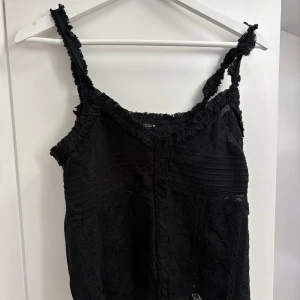 Svart spetsig linnetopp från Zara - Supersnygg svart linnetopp från Zara med spetsdetaljer och fransiga kanter. Jätte snygg💛