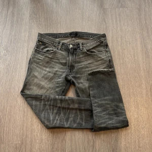 Grå jeans från Polo Ralph Lauren - Snygga grå jeans från Polo Ralph Lauren med slitna detaljer och klassisk femficksdesign. Jeansen har raka ben, normal passform och är tillverkade i bomull. Perfekta för dig som gillar en avslappnad men stilren look.