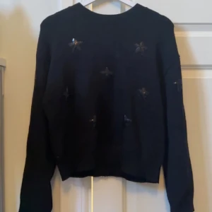 Svart stickad tröja💝 - Snygg svart tröja med glittrande paljettdetaljer i form av stjärnor från gina young. Tröjan har långa ärmar och en normal väldigt skön passform!! Storlek 146/152 men sitter vanligt på mig med XS/S💓
