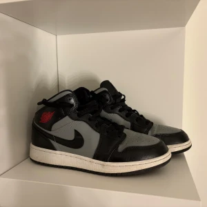 Nike air Jordan 1 Mid shadow red str 38 - Jag  köpte  dessa skori fel storlek men behöll dem ändå och har bara använt dem ett fåtal gånger med crease-skydd. De är i nyskick och har mest stått som en del av min samling. Skorna är alltså väldigt lite använda och redo att säljas vidare i nyskick. Storlek 38 (24 cm). Tyvärr har jag inte kvar lådan. Ny pris 1799kr  Tveka inte på att ställa frågor!