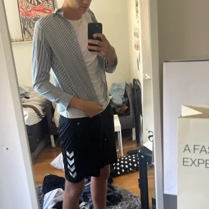 Randig blåvit skjorta med krage - Snygg skjorta med smala blå och vita ränder, klassisk krage och långa ärmar. Skjortan har en rak passform och är tillverkad i mjukt bomullstyg. Perfekt för dig som gillar stilrena och enkla plagg med lite edge.