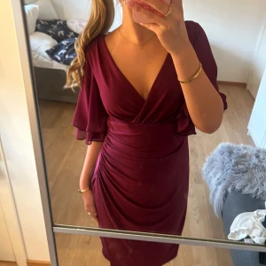 Vinröd klänning från Ralph lauren  - Säljer en vinröd långklänning med v-ringning. Klänningen har volangärmar och snygga draperingar längs midjan och höften. Perfekt för dig som vill ha en elegant och feminin look med extra flow i ärmarna. Storlek 8 som motsvarar ungefär storlek 40 men den passar mig som har storlek S💗 aldrig använd 