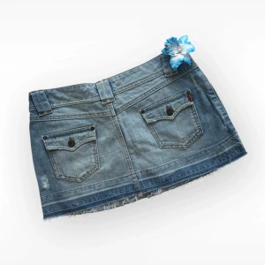 Blå lowwaist jeanskjol från Oasis - Säljer en blå jeanskjol från Oasis med rå, fransig kant och slitna detaljer. Kjolen har klassiska jeansfickor både fram och bak, bälteshällor och knappstängning. Perfekt för dig som gillar en avslappnad och cool stil.