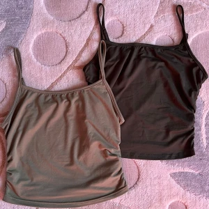 Två basic linne-toppar i grön och mörkgrön - Säljer två stilrena linne-toppar med smala axelband, en i grön och en i mörkgrön. Båda är ärmlösa och har en enkel, rak form som är lätt att matcha med olika outfits. Materialet känns mjukt och stretchigt, perfekt för varma dagar eller lager-på-lager. Ej använt. Tar endast 79 för båda!💓Storleken är M men skulle säga att den skulle passa dig om du har storleken S!!