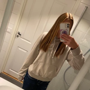 Beige hoodie med snörning - Säljer en beige hoodie med huva och snörning framtill.