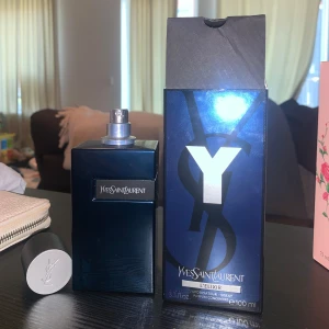 Yves Saint Laurent Y L'Elixir 85ml - Y L'Elixir från Yves Saint Laurent är en parfym i en stilren, mörkblå glasflaska med silverdetaljer och logotyp på locket. Flaskan rymmer 100 ml och kommer med originalkartong i matchande blått och silver. En modern och lyxig doft för dig som gillar exklusiva parfymer.