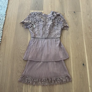 Lila spetsklänning från AX Paris - Köpte på loppis får 2 år sedan, aldrig använd. Köpte den för 20 därför säljer jag den för 20🩷 klänningen är lila med gulligt spets material på över delen. Dragkedja bak i ryggen med två pärl knappar i nacken🩷