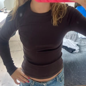 Brun långärmad tight tröja - Säljer en enkel och stilren brun långärmad tröja med rund hals. Modellen är tight och passar perfekt till jeans eller kjol, så fin!! Aldrig använd! 