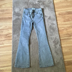 Grå flare jeans från 157 Skippy - Snygga grå jeans från lager 157 i modellen Skippy Flare. Jeansen har klassisk femficksdesign, utsvängda ben och normal midja. Perfekta för dig som gillar retrovibbar och vill ha en cool siluett. Materialet är mjukt denim som sitter skönt hela dagen.