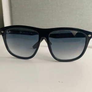 Ray-ban Boyfriend glassögon - Unika svarta solglasögon från Ray-Ban med Grå/Blå mörk tonade glas. Snygg och tidlös design med diskret Ray-Ban-logga på linsen. Köpta i Milano. Dem är använda men i riktigt bra skick. Tveka inte att kontakta om vidare funderingar.