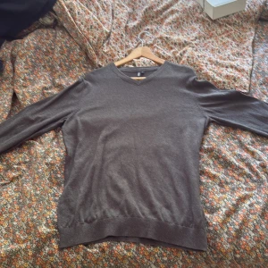 Mörkbrun v-ringad tröja H&M - Säljer en enkel och stilren mörkbrun v-ringad tröja från H&M. Tröjan har långärmade ärmar och är gjord i mjukt material som känns skönt mot huden. Perfekt för dig som gillar en clean look och vill ha något som funkar till jeans eller chinos.