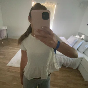 Vit t shirt med volang  - Vit T-shirt med volang från lager 157 i strl 150. Använt några gånger men inte så mycket längre så säljer därav.