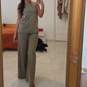 Beiga vida stickade byxor & topp - Säljer ett par snygga stickade byxor & topp i beige med breda ben och relaxed fit. Byxorna har hög midja och är perfekta för en chill och trendig look. Mjukt material som känns skönt mot huden och passar till många olika outfits.