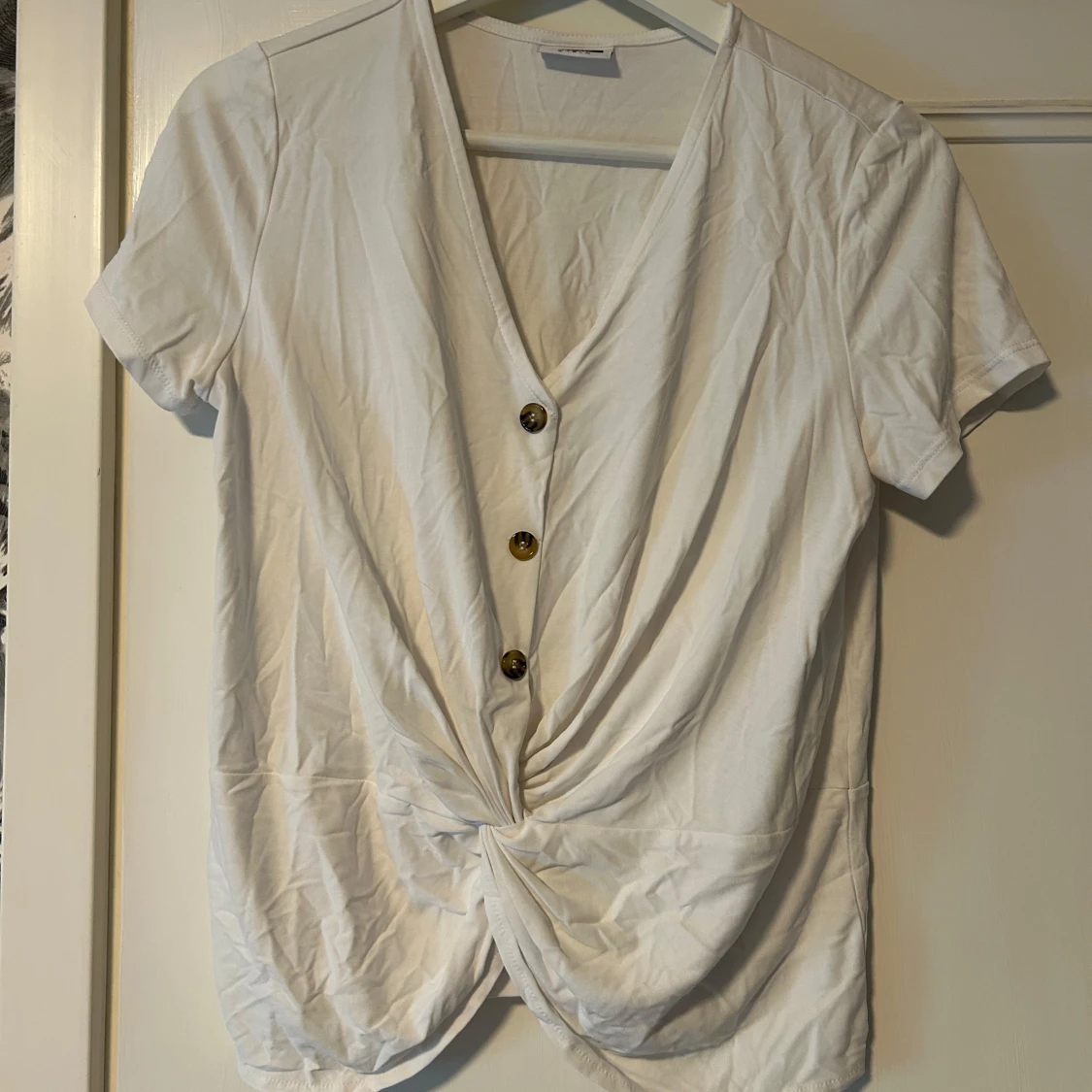 Vit blus med dekorativa knappar