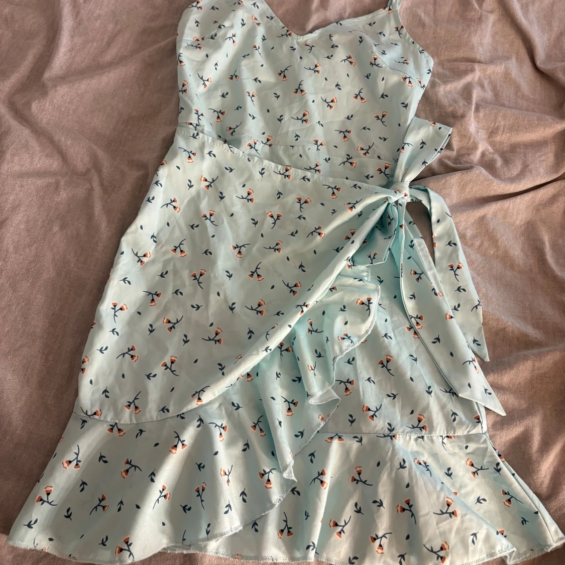 Ljusblå blommig omlottklänning