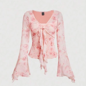 Rosa blommig mesh blus med trumpetärm - Supersöt blommig meshblus i ljusrosa med långa trumpetärmar och knyt framtill. Toppens meshmaterial ger en luftig känsla och de romantiska rosorna gör den extra gullig. Använd några gånger men inga täcken på det. Den är i storlek M men är ganska så stretchig.