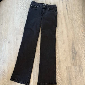 Svarta bootcut jeans från 157 - Svarta jeans från 157 med bootcut-modell och klassisk femficksdesign. Jeansen har raka ben med lätt utsvängning nertill och snygga bakfickor med lock och knapp. 