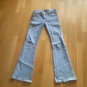 Ljusblå bootcut jeans XXS Tough Love - Ljusblå jeans från Tough Love i bootcut-modell med klassiska fickor. Jeansen har låg midja och är tillverkade i bomull. En fläck på ena knät som knappt syns när man har på sig dem. Säljer pga att dem är försmå. Den är väldigt lågmidjade🩵🩵