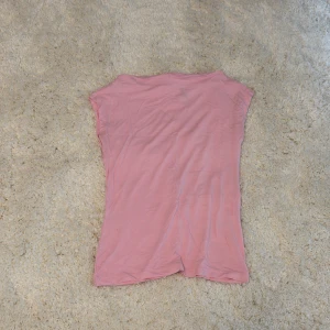 Rosa ärmlös topp från 157, XS - Söt ljusrosa topp från 157 i storlek XS. Modellen är ärmlös med enkel, rak passform och rund halsringning. Knappt använd 
