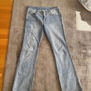 Ljusblå bootcut jeans - ljusblåa lågmidjade bootcut jeans från brandy mellvin, Jeansen är lite slitna längst ner men de är inget man tänker på. Fråga gärna om mått eller bilder med dem på!🥰