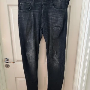 Mörka slitna jeans med skinny fit - Säljer ett par mörkblå jeans med slitningar och snyggt tvättad look. Modellen är comfort/mike