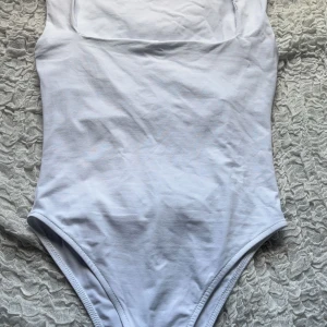Vit body från Zara - Supersnygg vit body från Zara i storlek S. Perfekt att styla med jeans eller kjol för en fräsch look. Den har en liten sminkfråga på sidan (se sista bilden) men inget man tänker på, annars jättebra skick!