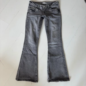 Grå bootcut jeans med låg midja - Grå bootcut jeans med låg midja. Köpta från Gina Tricot, Scandi low waist bootcut jeans. Endast använda 1 gång (för stora för mig tyvärr) och nyskick! Nypris 360 kr, helt slutsålda på Gina