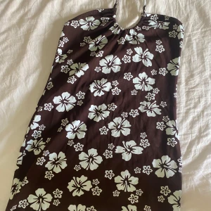 Brun klänning med blommor - jag säljer denna klänning just för att den är i L och jag är S. Jag tycker att den skulle kunna passa nån i strl M också! Den är aldrig använd, har inga hål/märken!