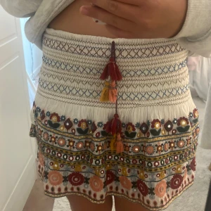 Broderad kortkjol med tofsar - Superfin kortkjol ifrån Zara! Säljer pågrund av att jag inte använder den!💓några plast saker saknas och lite sådant men inget som syns vid användning!💓💓