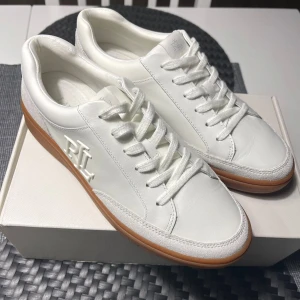 Brand New Ralph Lauren, Hailey VI White Leather Sneakers - Eu40 - Brand New Ralph Lauren, Hailey VI White Leather Sneakers. (Hailey 6-SK-LTL , Snow White) Original Price : 1800kr. More photo can be shared if requested. 