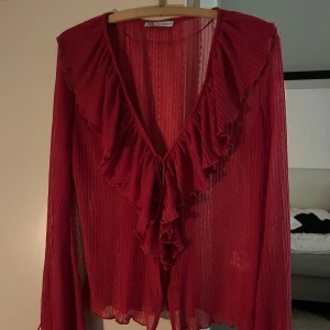 Röd volangblus från Zara - En rosa/röd transparent blus från Zara med långa ärmar och volangdetaljer. Strl M
