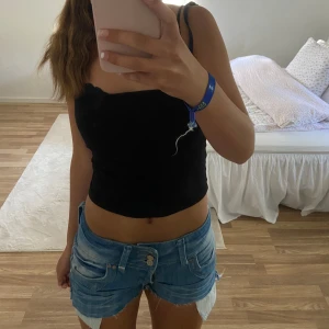 Blåa jeansshorts  - Självklippta jeansshorts från revers med tre olika knappar. Mönster på bakfickorna och lågmidjade skulle jag säga.