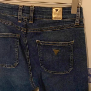 Guess jeans - Snygga blå jeans från Guess med klassisk femficksdesign och en diskret logga på bakfickan.  Fint skick, knappt använda! Storlek W25