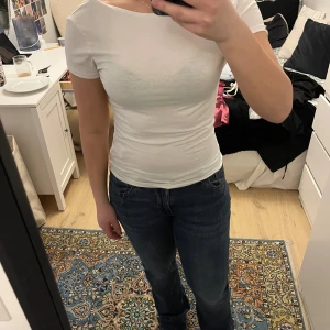 Vit kortärmad topp - Säljer en stilren vit kortärmad topp med rund halsringning. Perfekt för en enkel och fräsch look. Passar bra till jeans eller kjol.