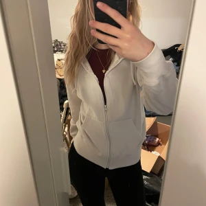 Vit hoodie med dragkedja - Säljer en vit hoodie med dragkedja och huva.  Perfekt för kyliga dagar eller mysiga hemmakvällar. Passar mig bra som vanligtvis bär XS. OBS! Tröjan har mindre fläckar. Bara att höra av sig vid frågor 💕