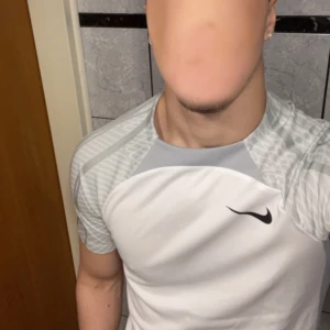 Vit och grå t-shirt från Nike - Nike Dri-Fit träningströja, storlek S. Skicket är perfekt med undantag för slitage på bröstet. Slitage är inte synligt vid användning.