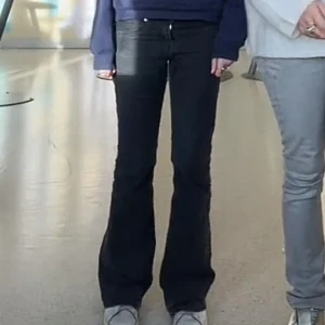 Svarta bootcut jeans - Jag är 170! Snygga svarta bootcut jeans med hög midja. Perfekta för en stilren look. De har en klassisk design med dragkedja och knappar framtill.