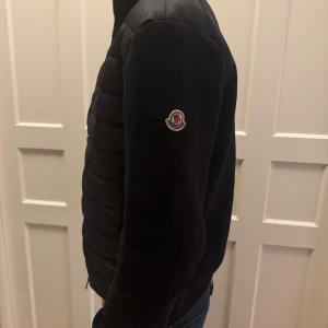 mörk blå quiltad jacka från Moncler - Snygg mörkblå quiltad jacka från Moncler med dragkedja framtill. Jackan har en stilren design med långärmade ärmar. Skick 9/10 nästan aldrig andvänd. passar perfekt till någon som är cirka 170cm sitter även bra på folk som är kortare och längre.