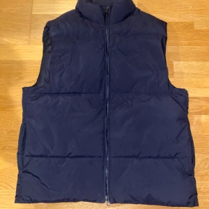 Svart dunväst från East West - Säljer en snygg svart dunväst från East West. Västen har inga tecken på användning, mycket bra skick! Storlek M sitter perfekt. Skriv gärna vid minsta lilla.