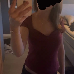Vinröd topp från Anna field - Säljer en vinröd topp med korta ärmar och v-ringad hals. Perfekt för en stilren och enkel look. Passar bra till både jeans och kjol.