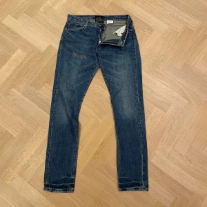 Blå Acne studios jeans - Snygga blå jeans från Acne med klassisk femficksdesign och dragkedja. De har en slim/straight passform och är perfekta för en avslappnad stil. Detaljer som en läderpatch på baksidan ger en extra touch. Skriv privat för fler bilder eller funderingar😇