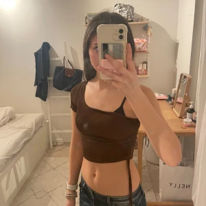 Brun oneshoulder topp - Säljer en snygg brun oneshoulder topp med kort ärm. Toppen är croppad och har en stilren design som passar perfekt till jeans eller kjol. Perfekt för en kväll ute eller en avslappnad dag.💕❤️