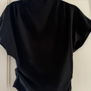 Svart blus från H&M - Jättefin svart blus som sitter tajtare runt midjan! Säljer då den inte passa mig längre 