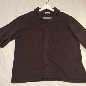 Brun skjorta från Filippa K - Snygg brun skjorta från Filippa K i storlek M man passar även L. tröjan får dig att se väldigt muskulös Perfekt för en stilren look. Tröjan kan användas som en överkört eller en fet sommar tröja. Hör av er vid frågor😁 