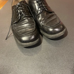 Svarta skinnskor från Dahlin - Klassiska svarta skinnskor från Dahlin med snörning. Perfekta för en stilren look. Skorna har en robust sula och en elegant design som passar till många tillfällen. Köpte dem för 2000kr nya men tyvärr inget kvitto. Bra skick