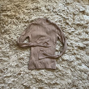 Beige ribbad polotröja - Beige ribbad polotröja med långa ärmar. Väl använd men i fint skick.
