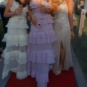 Ljuslila volangklänning - Säljer en fantastisk ljuslila balklänning med volanger. Klänning har en fantastisk design och är perfekt för festliga tillfällen. Den har en romantisk och elegant stil som verkligen sticker ut. Det är lånade bilder men skriv till mig så kan jag skicka fler. Den är fin till bal och säljer för bra pris då jag vill få den såld. 