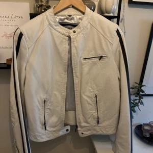 Vit skinnjacka från Livelo - Snygg vit vintage skinnjacka från Livelo med svarta detaljer längs ärmarna.  Äkta skinn. Står storlek 42 men skulle säga mer som runt 38/40💕